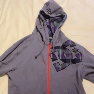 DC zip up hoodie - Snygg DC zip up hoodie, viktigt att nämna att denna hoodie är inte faktiskt från DC, om ni fattar vad jag försöker åstadkomma med  Mått: Längd 64 cm Bredd 49 Cm