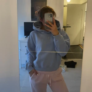 Ljusblå hoodie - Säljer en ljusblå hoodie med huva och ficka framtill. Tröjan har en avslappnad passform och långa ärmar. Perfekt för en chill och bekväm stil.