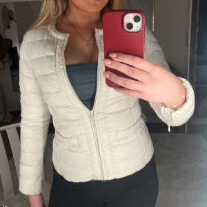 Vit tight dun liknande jacka  - Säljer en vit tight qualitad liknande jacka från Holly & Whyte. Jackan har dragkedja framtill fickor, lång ärm och figur passform. Är osäker över storlek men gissar på storlek S