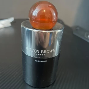 Molton Brown Neon Amber Eau de Parfum - Molton Brown Neon Amber är en parfym med en modern och djärv doftprofil. Doften har tydliga inslag av amber, trä, vanilj, mysk och sötma. Riktigt god amber doft ! Säljer denna då jag hittat en annan amber doft, det är en 100ml flaska och skulle uppskatta att det finns 85-90ml kvar !