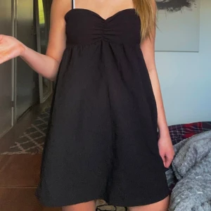 Svart klänning - Säljer en svart  klänning med söt rynkning vid bysten. Klänningen har en luftig passform och är perfekt för varma dagar. Enkel och stilren design som passar till många tillfällen.