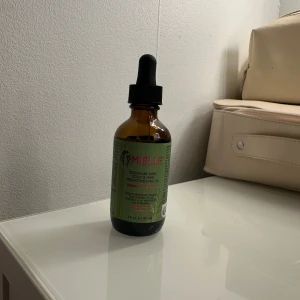 Mielle Rosemary Mint Strengthening Oil - Mielle Rosemary Mint Strengthening Oil i brun glasflaska med pipett. Oljan är framtagen för hår och hårbotten och innehåller rosmarin och mynta. Perfekt för att ge näring och styrka till håret.