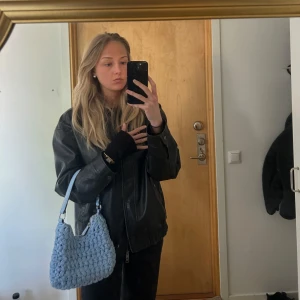 Blå vädka - Säljer en blå väska i ”virkat” material. Passar att ha på underarm, alternativt att använda förlängningsbandet över axeln. Jätte fin detalj till en färglös outfit! Rejäl material.