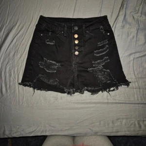 Högmidjade svarta slitna shorts str S - Högmidjade svarta jeans shorts med slitningar, storlek S  Använda enstaka gånger Fickor fram och bak, alla funkerande. Knäppning med knappar. Väldigt stretchiga!  Nypris:189kr  Kläderna rollas innan dom skickas då katt finns i hemmet!  #jeansshorts #svartajeansshorts #blackjeansshorts #wilmabookss #wilmabooksstorleks