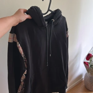Svart hoodie med rutiga detaljer från Burberry - storlek XL men passar M