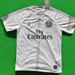 Vit Paris Saint-Germain fotbollströja - Snygg vit PSG fotbollströja med svarta detaljer, Fly Emirates-tryck och Jordan-logga på bröstet. Rund halsringning och korta ärmar. Materialet är lätt och andas, perfekt för träning eller match.