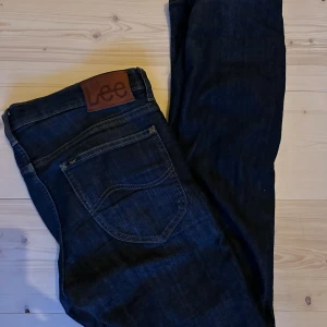 Lee Jeans - Säljer nu dessa snygga jeans från Lee. Skick: 9/10. Storlek: W29 (längden passar dig som är ca 170-180 cm lång). De är mörkblåa. 