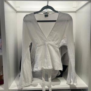 Vit omlottopp från Gina Tricot - Säljer nu denna fina topp från Gina tricot 🌸toppen är i väldigt bra skick och bara använd 2 gånger. Storleken är dam xs 🩷// Emma
