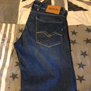 Mörkblå jeansbyxor från Replay - Snygga mörkblå slim-jeans från Replay med klassisk femficksdesign och tydliga kontrastsömmar på bakfickorna. Byxorna har läderpatch med Replay-logga bak i midjan och raka ben. Storlek 32/32. Fint skick 🙌