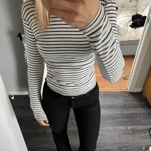 Vit och svart randig ribbad långärmad tröja - Säljer en vit långärmad tröja med svarta tunna ränder. Tröjan är ribbad och har en tight passform i storlek xs