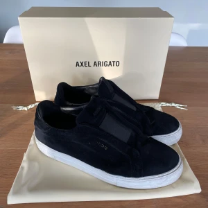 Svarta sneakers från Axel Arigato i mocka - Säljer ett par svarta sneakers i storlek 44 från Axel Arigato! Modellen är 360 clean i färgen svart. De är köpta förra vintern för 2500 men är i bra skick. jag säljer de för att jag inte använder de längre. Dust bag, box och självklart skorna följer med.