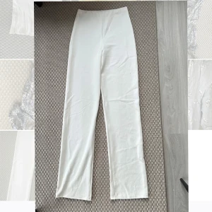 Vita kostymbyxor - Säljer ett par vita classy kostymbyxor från Nelly! Super sköna och mjuka, rekommenderar som med många andra vita byxor att ha neutral färg på underkläder, svarta lyser igenom en aning 💕🌷