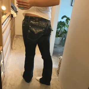 Mörkblå jeansbyxor från Miss Me - Miss me jeans i modellen boot, storlek Waist 29.  (Jeansen har små fläckar som syns på bilden längst bak, de borde gå bort i tvätten har ej testat, köpte de secondhand (för 1600kr) och de kom såhär, har ej använt de)  Ställ frågor vid funderingar!☺️  #y2k #y2kjeans #missme #missmejeans #truereligion #truereligionjeans #boot #flare #utåtsvängda #lowwaist #lågmidjat #stockholmstil #stockholmstyle #sthlmstyle #trendigt #2025 #spring2025 #trendy #y2kstyle