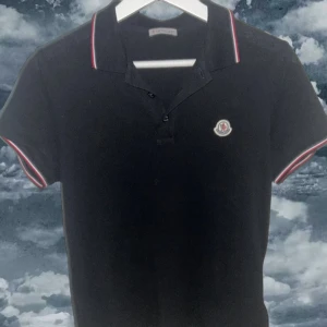 Svart pikétröja från Moncler - En klassisk piké tröja från moncler i storlek  S ✨Perfekt för en lite finare och stilren look. Ny pris:3500kr                            Pris kan diskuteras via snabb affär.
