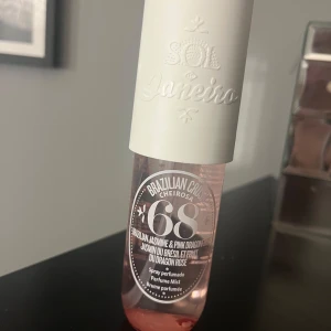 Sol de Janeiro Brazilian Crush Cheirosa 68 Perfume Mist - En fräsch och blommig body mist från Sol de Janeiro med doft av brasiliansk jasmin och pink dragonfruit. Flaskan är genomskinlig med rosa vätska och har ett vitt lock med präglad logga. Perfekt för dig som gillar söta och tropiska dofter.