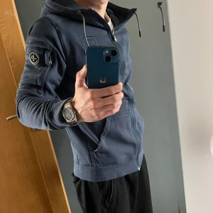 Blå hoodie från Pelle P - Otroligt skön och snygg ”Pelle p” hoodie i storlek s. Endast använd ett par gånger, skicket på hoodien är verkligen super bra (10/10) och har inga skavanker. Nypris ca 1300kr.