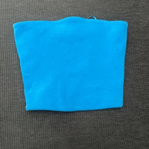 Blå tubtopp från Zara - Säljer en enkel och snygg blå tubtopp från Zara. Toppen är ärmlös och har en tight passform, perfekt att matcha med jeans eller kjol nu i sommar.