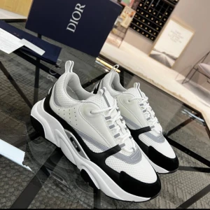 Dior B22 sneakers i vitt och svart - Säljer ett par Dior B22 sneakers i vitt och svart med inslag av grått. Box oxh tillbehör ingår också hör av dig för fler frågor eller bilder👋 finns att hämta i Göteborg. pris kan diskuteras vid snabb affär 