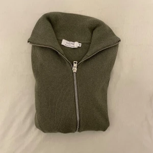 Olivgrön ribbad kofta från Ljung by Marcus Larsson - Säljer en olivgrön ribbad kofta från Ljung med dragkedja (fullzip). Tröjan har lång ärm och hög krage, perfekt för lager-på-lager. Stilren och fräsch design som passar till mycket. NYPRIS 1500kr (Brother)