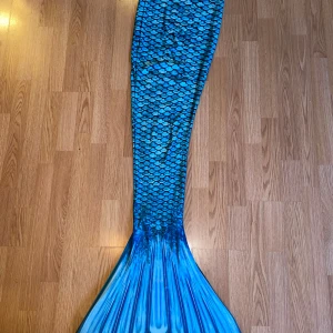 Blå sjöjungfrufena och monofena från Fin Fun - Säljer min blåa sjöjungfrufena från Fin Fun i storlek XS. Fenan har fiskfjällsmönster och inkluderar en monofena. Använd flera gånger, några små skrapmärken (se bild) men fungerar perfekt ändå!