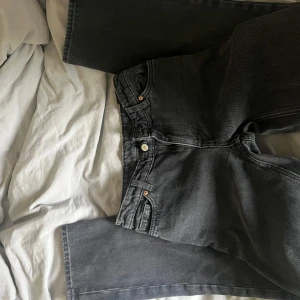 Svarta raka jeans från Monki - Säljer ett par svarta jeans från Monki med raka ben och klassisk femficksdesign. Jeansen har normal passform och stängs med dragkedja och knapp. Perfekta till vardags för en avslappnad stil.det sår ingen storlek men jag tror typ XS till XXS. Det är lite slitna högst upp på midjan💗💗