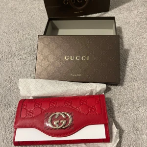 Röd plånbok från Gucci - Säljer en lyxig röd plånbok från Gucci tillverkad i skinn Kommer i originalask. Ställ gärna frågor innan du köper 
