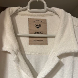 OAS frottéskjorta - Säljer en vit långärmad skjorta från OAS i mjuk frotté. Använd max 2 gånger och är i perfekt skick. Perfekt plagg till sommaren, skjortan är i storlek L och är köpt för 1300, har ni frågor eller funderingar så är det bara att fråga😁