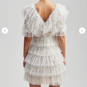 Vit spetsklänning med volanger - Perfekt studentklänning/ festklänning, aldrig använd! (Prislapp kvar på klänningen). Orginal pris: 2800kr 