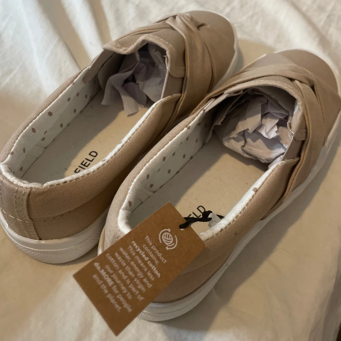 Beige slip-on sneakers med knutdetalj