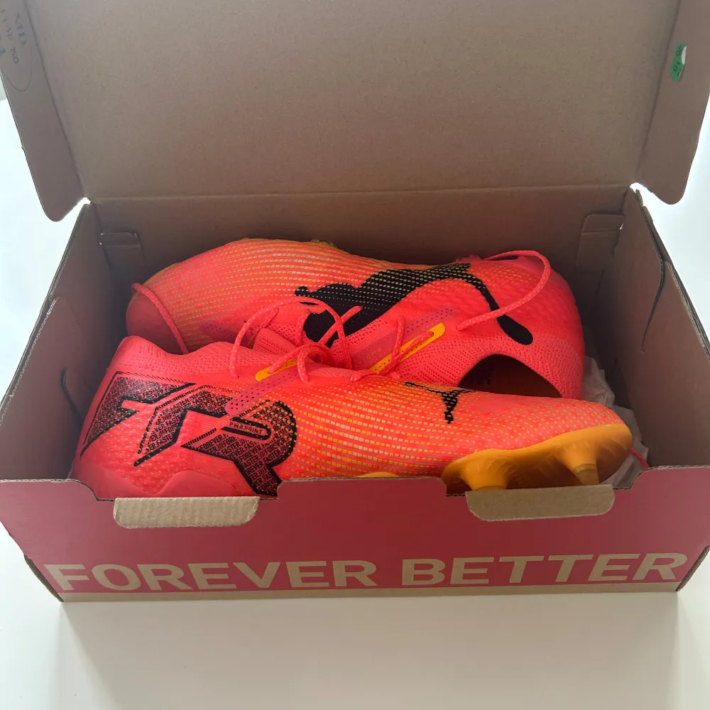 Snygga och färgglada fotbollsskor från Puma i en iögonfallande rosa nyans med svarta detaljer. Skorna har snörning och en lättviktig design som ger bra grepp på planen. Perfekta för att sticka ut under matchen!. Kengät.