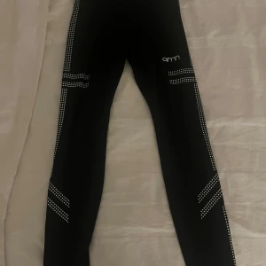 Svarta leggings från Aim'n - Snygga svarta leggings från Aim'n med vita prickdetaljer längs benen. Tillverkade i en mix av polyester och spandex för en bekväm och stretchig passform. Perfekta för träning eller en aktiv vardag. Skriv privat vid frågor eller funderingar💗