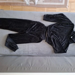 Svart velour set från Iron - Säljer ett svart velour set från Iron. Setet består av en långärmad tröja och matchande byxor med resår i midjan. Perfekt för en avslappnad dag hemma eller en stilren look på stan.
