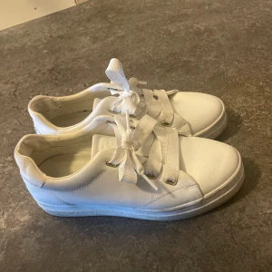 Vita GANT  sneakers med breda snören - Snygga vita sneakers med breda snören och en klassisk design. Perfekta för en stilren look och passar till det mesta i garderoben.