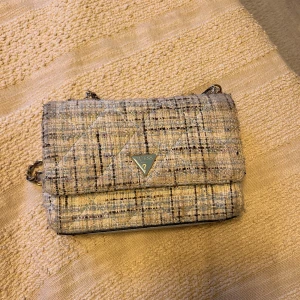 axelväska från Guess - Säljer en stilren rutig axelväska från Guess med kedjerem. 
