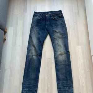 Lee - 125th Anniversary Jeans: Mörkblå jeans från Lee - Lee’s 125th anniversary jeans edition. Använts 2 gånger. Helt fräscha som nya. Nice wash och relaxed jeans. De har en klassisk femficksdesign och slitna detaljer för en vintage look. Perfekta för en avslappnad stil.