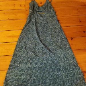 Blå blommig klänning från Bik Bok - Säljer en söt blå klänning med små vita blommor från Bik Bok. Klänningen har smala axelband och en liten öppning framtill. Perfekt för sommarens varma dagar! 🌸 Använd få gånger