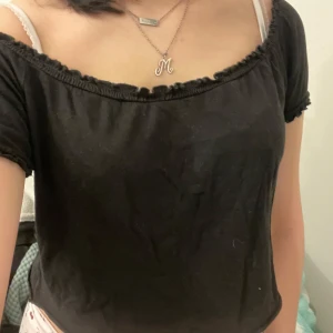 Svart offshoulder topp - Säljer en svart offshoulder topp med korta ärmar och ribbade kanter. Perfekt för en avslappnad stil. Passar bra till både jeans och kjol.