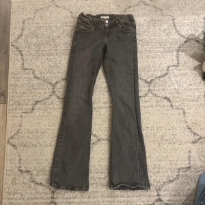 Grå jeans från Gina Tricot - Gråa jeans från Gina Tricot i storlek 158. Fickor där bak. Passar på mig som är ungefär 167cm lång där mina ben är ganska långa och brukar bära på xxs eller xs. Finns band i jeansen i midjan.