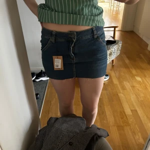 Jeanskjol i mörk denim - Snygg jeanskjol i mörk denim med klassisk femficksdesign. Kjolen har en kort längd och rå kant nedtill.💕💕 köp på Sellpy men den är från h&m. Säljer då den tyvärr var för liten för mig. Pris kan diskuteras! 
