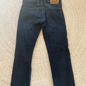 Mörkblå jeans från Replay - Snygga mörkblå jeans från Replay. Modellen är Grover
