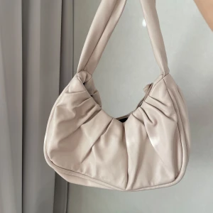 Beige axelväska - Beige rymligt handväska. Osäker på varumärke men tror den är från Asos.