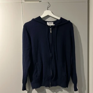 Mörkblå cashmere/merino hoodie - Säljer en snygg mörkblå hoodie från Livanno i bra skick. Den har en dragkedja framtill och en skön huva. Perfekt för höst och vinter när du vill hålla dig varm och bekväm. Passar till både vardag och chillkvällar. 🧥💙(är öppen för byten)