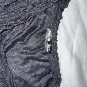 Svart ribbad topp från Shein - Säljer en svart ribbad topp från Shein med långärmad design. Perfekt för en stilren look. Toppen har en åtsittande passform och är tillverkad i ett mjukt material.