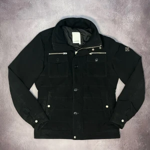 J.Lindeberg Field jacket  - Tja! Säljer denna feta svarta J.Lindeberg Field jacket för bara 1599kr! Nypris ligger på 3600+kr. Storlek M, lite för stor för mig som är 175cm o väger 65kg. 8/10 skick. Lagning på höger ficka o små tecken på användning. Priset går alltid att diskuteras. Hör av dig vid funderingar.