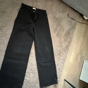 Svarta wide leg jeans från Lindex💓 - Säljer ett par svarta jeans från Lindex i modellen Jackie. Byxorna har breda ben och klassisk femficksdesign med knapp och dragkedja framtill. Perfekta för dig som gillar en avslappnad och trendig stil.