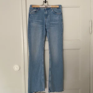 Ljusblå bootcut jeans från Zara - Säljer dessa lågmidjade Zara jeans då de tyvärr inte kommer till användning. De är klippta i benen, men annars helt i nyskick. Kan gå ner i pris vid snabb affär💕 Midjemått rakt över: 36 cm    Innerbenslängd: 76cm