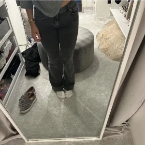 Grå bootcut jeans - Säljer ett par gråa bootcut jeans med låg midja. Jeansen har klassisk femficksdesign och raka ben med lätt utsvängning nertill. Perfekta för en avslappnad och trendig look. ( finns lite slitningar längst ner vid hälen)