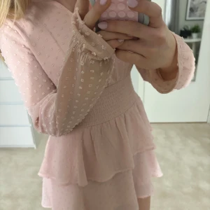 Ljusrosa volangklänning med prickigt mönster - Supersöt ljusrosa klänning med volanger. Säljer då den inte kommer till användning längre. Den är i storlek 158/164, skulle säga att den sitter som xs. Perfekt nu till våren och sommaren, inga defekter💞