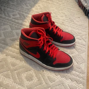 Nike Air Jordans i rött och svart - Säljer ett par klassiska Nike Air Jordans i rött och svart med högt skaft och röda snören. 