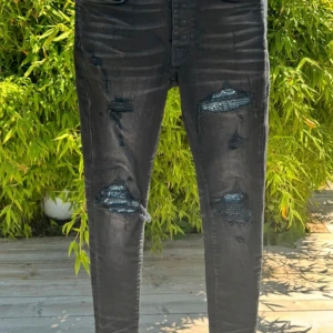 Svarta skinny jeans med slitningar från Amiri - Säljer ett par svarta  jeans från Amiri i storlek w30. Byxorna har flera slitningar och trasiga detaljer framtill för en edgy look. Klassisk femficksmodell med knappgylf.
